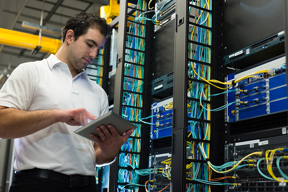 IT technician working on network servers and cables.